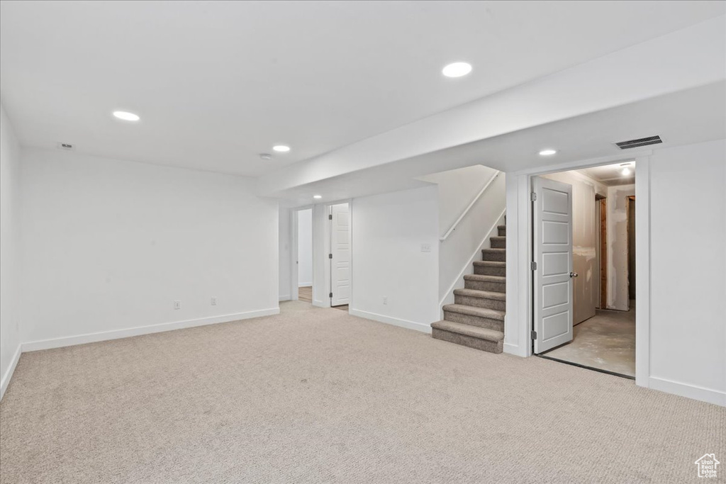 Finished below grade area with stairway, carpet flooring, baseboards, and recessed lighting