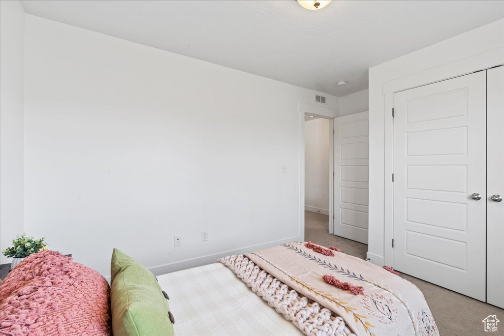 Bedroom with light colored carpet and baseboards