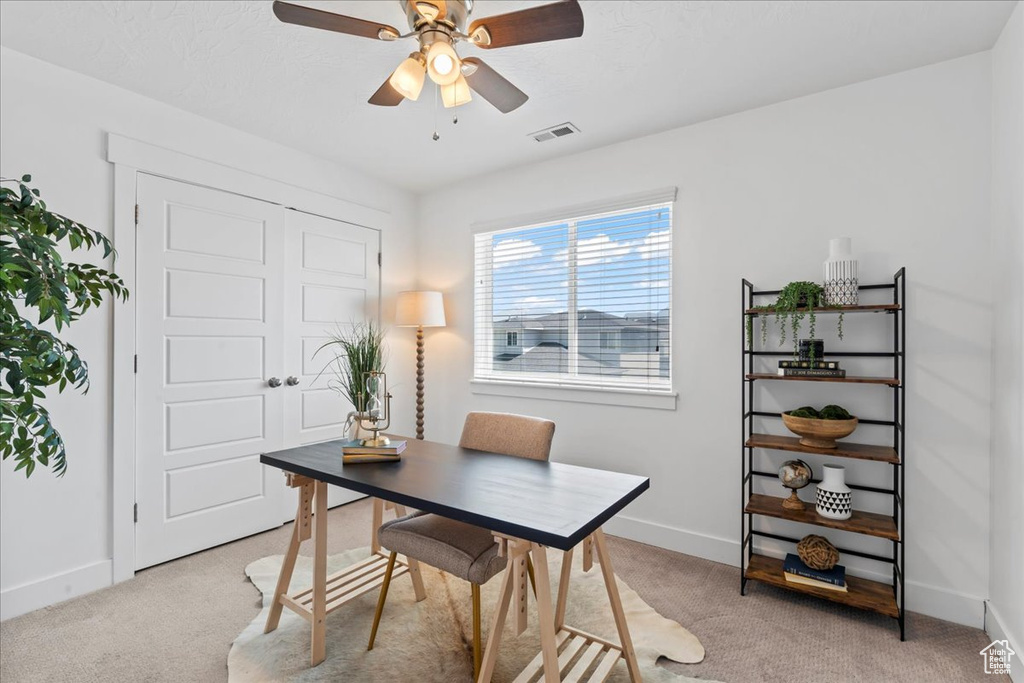 Office featuring light colored carpet, baseboards, and a ceiling fan
