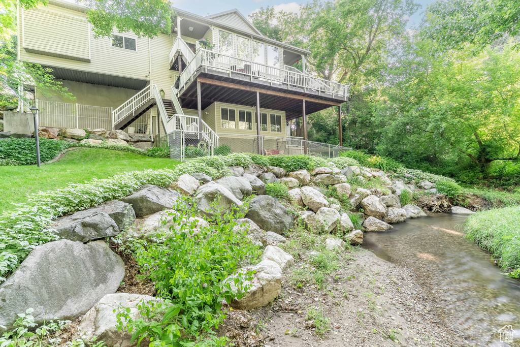 Rear view of house with stairs and a deck