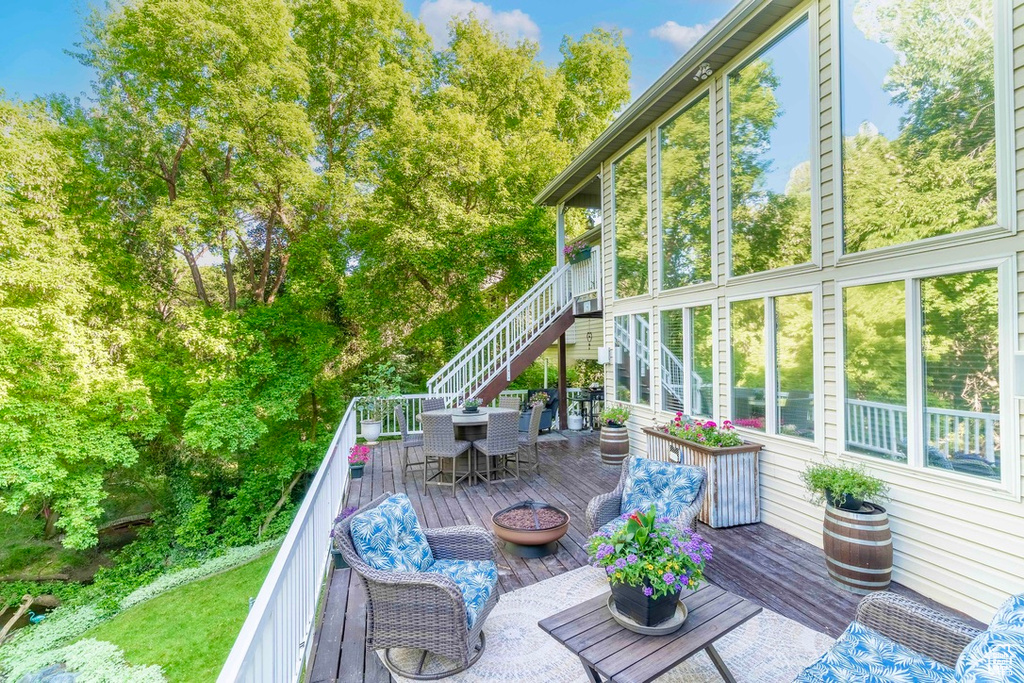 Wooden deck featuring outdoor dining space and stairway