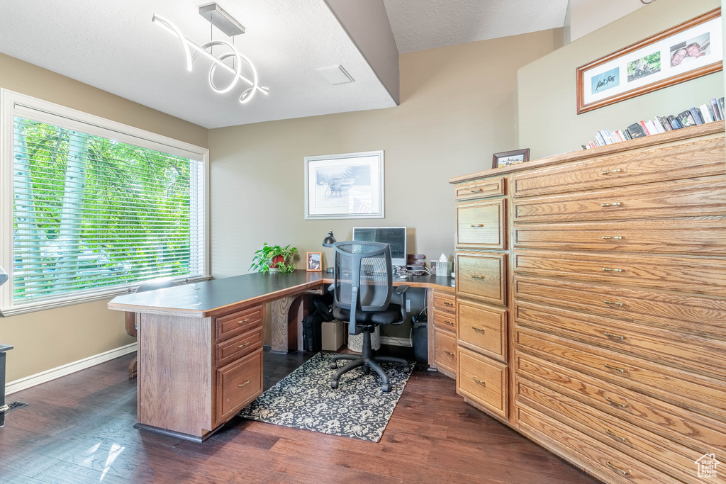 Office space with dark wood-style flooring and baseboards