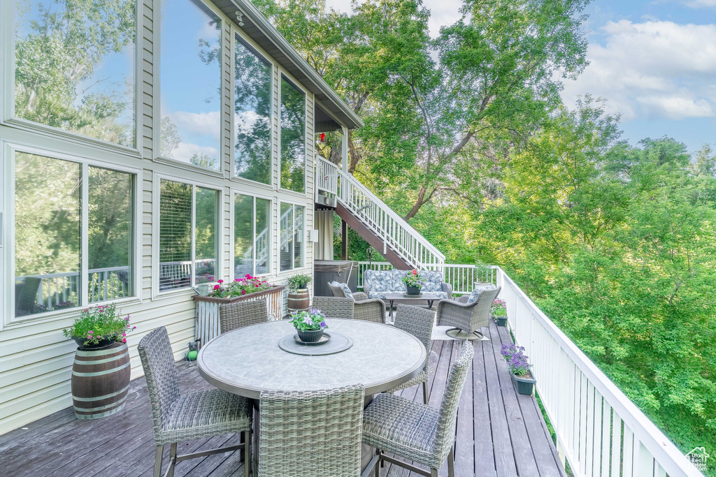 Wooden terrace featuring outdoor dining area and stairway