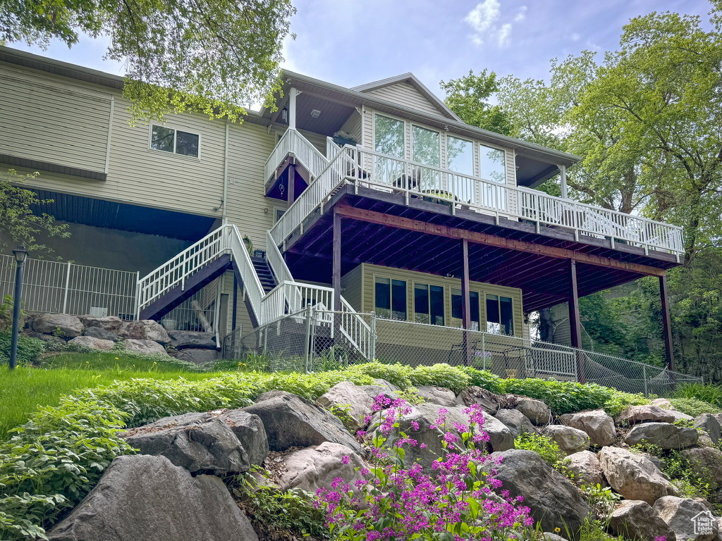 Rear view of house with stairway and a deck
