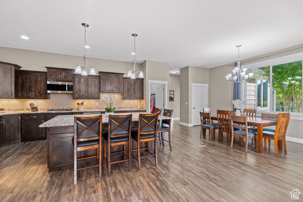 Kitchen featuring stainless steel appliances, dark wood finished floors, dark brown cabinets, baseboards, and recessed lighting
