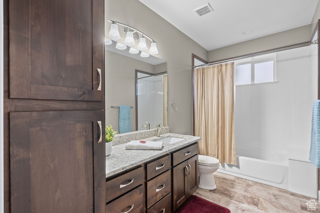 Bathroom featuring vanity, toilet, and shower / tub combo with curtain