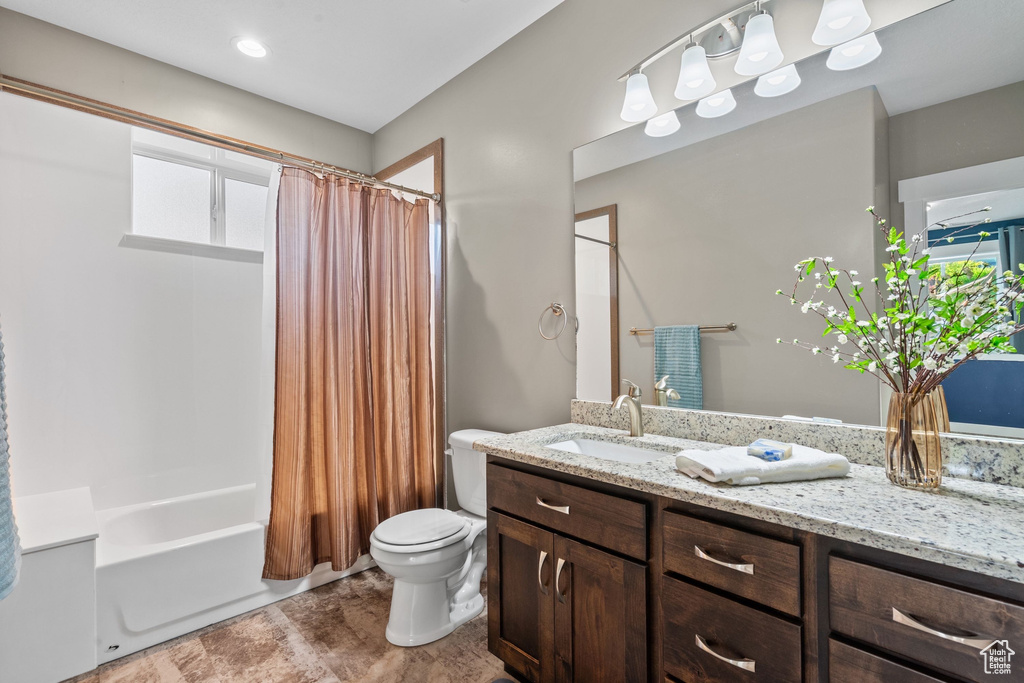 Full bath featuring vanity, toilet, and shower / bathtub combination with curtain