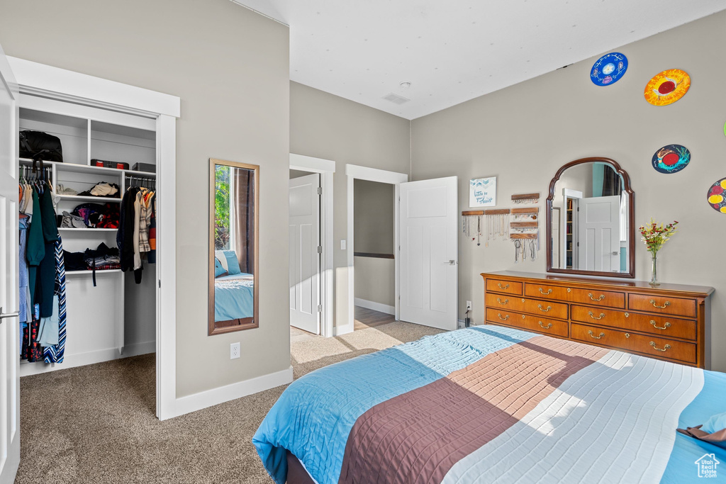 Bedroom with carpet flooring, baseboards, a closet, and a walk in closet