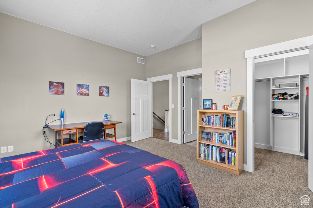 Carpeted bedroom with a closet and baseboards