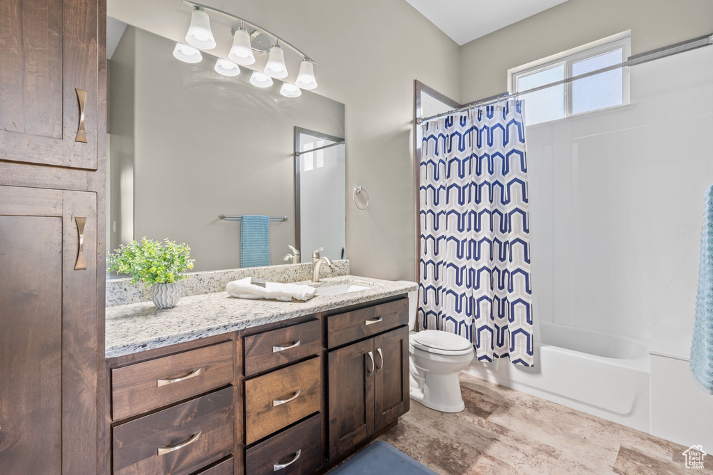 Full bath featuring toilet, vanity, and shower / bath combination with curtain