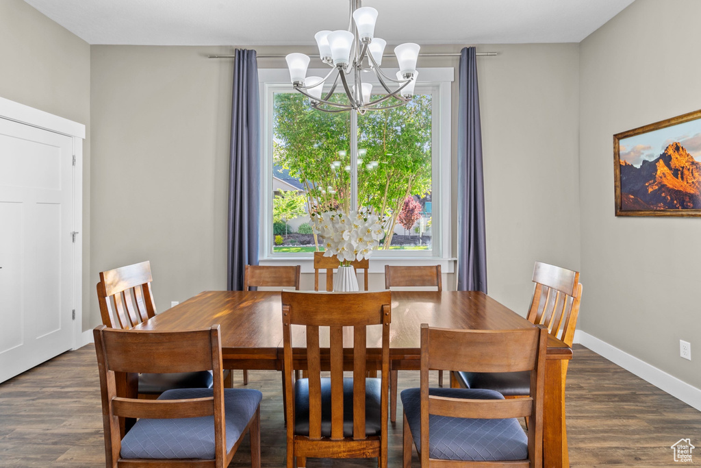Dining area with a chandelier, dark wood-style flooring, and baseboards