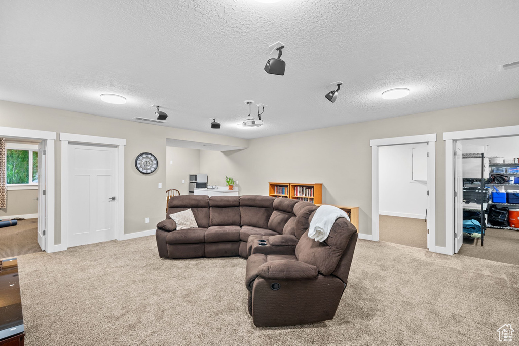 Carpeted living room with a textured ceiling and baseboards