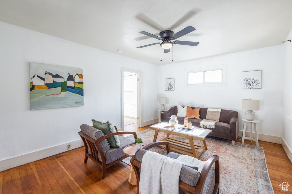 Living room with hardwood / wood-style floors, a ceiling fan, and baseboards
