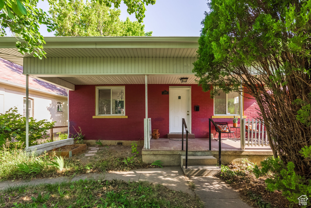 View of front of home with a porch and brick siding