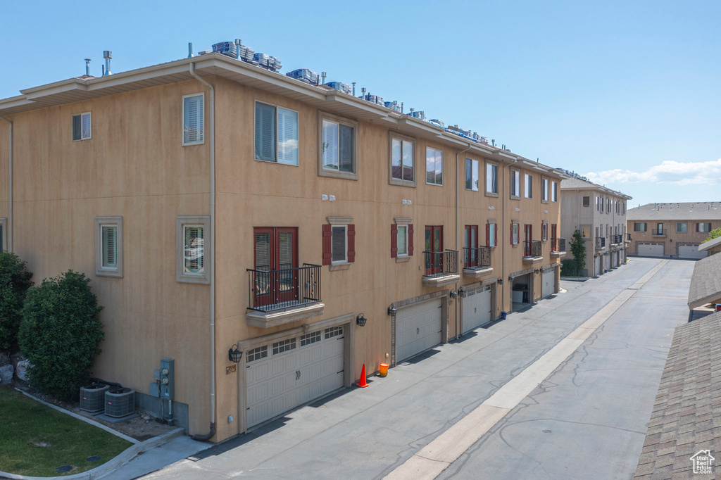 View of property with an attached garage and central AC