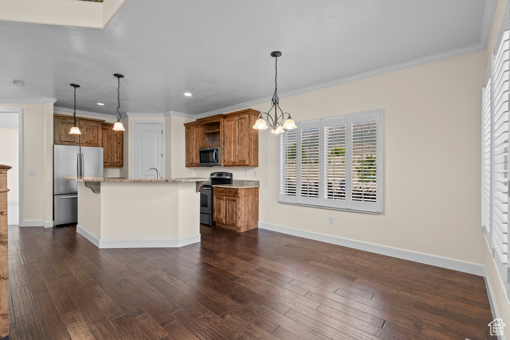 Kitchen featuring appliances with stainless steel finishes, brown cabinets, open shelves, a kitchen island with sink, and crown molding
