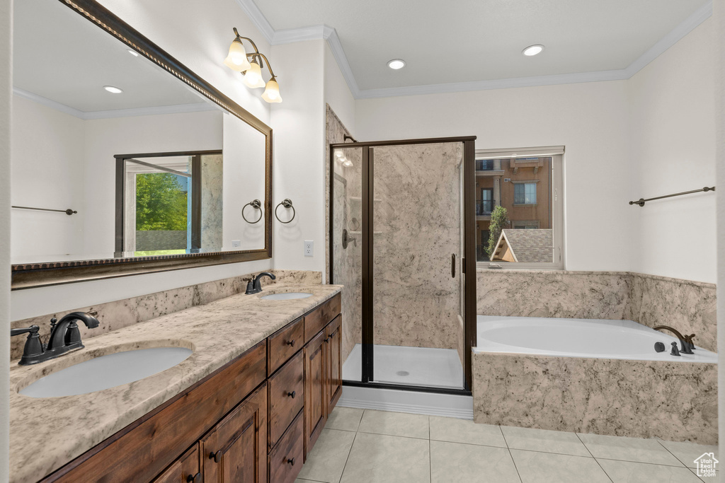 Bathroom with a bath, tile patterned floors, a stall shower, double vanity, and ornamental molding