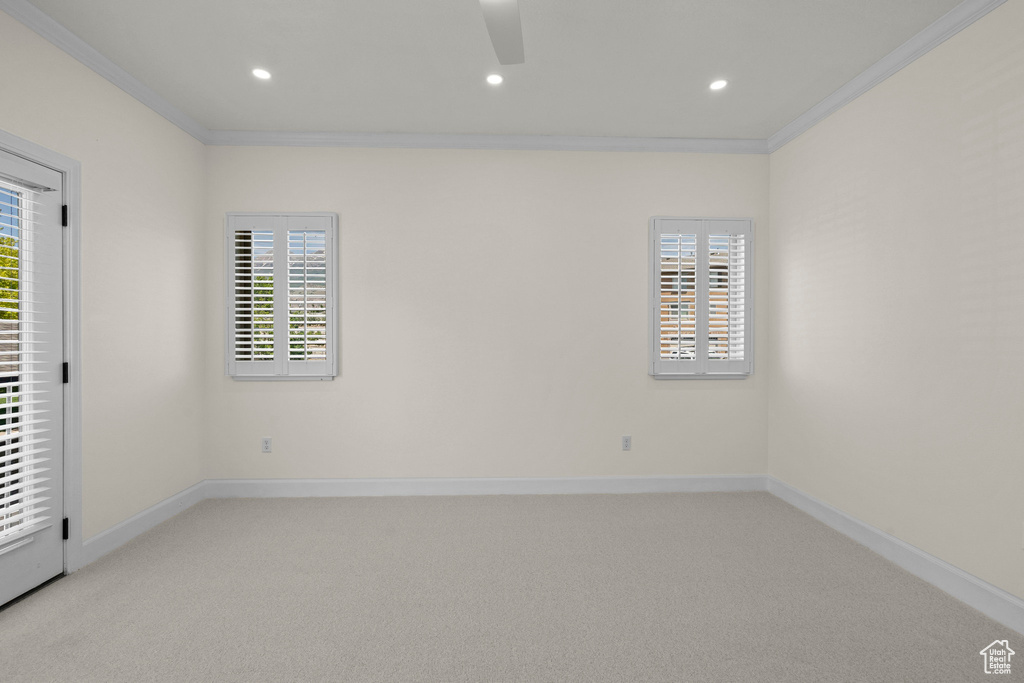 Unfurnished room featuring crown molding, light carpet, ceiling fan, healthy amount of natural light, and recessed lighting