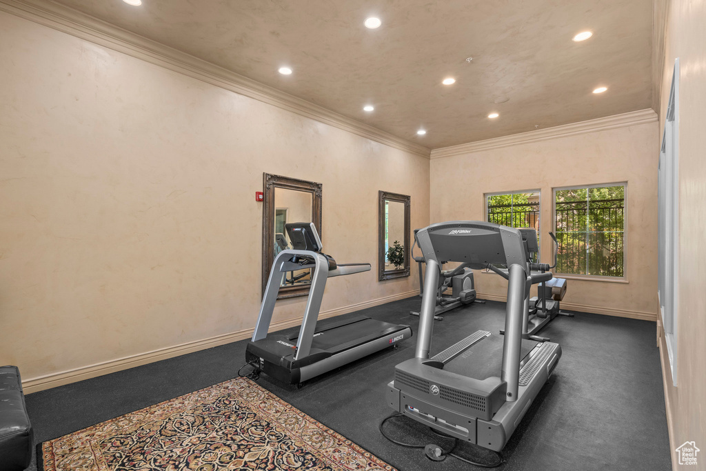 Exercise area with ornamental molding, recessed lighting, and baseboards