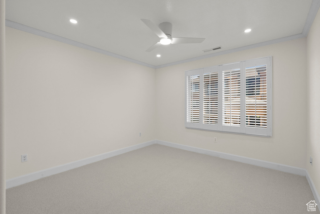 Carpeted spare room featuring ornamental molding, ceiling fan, baseboards, and recessed lighting