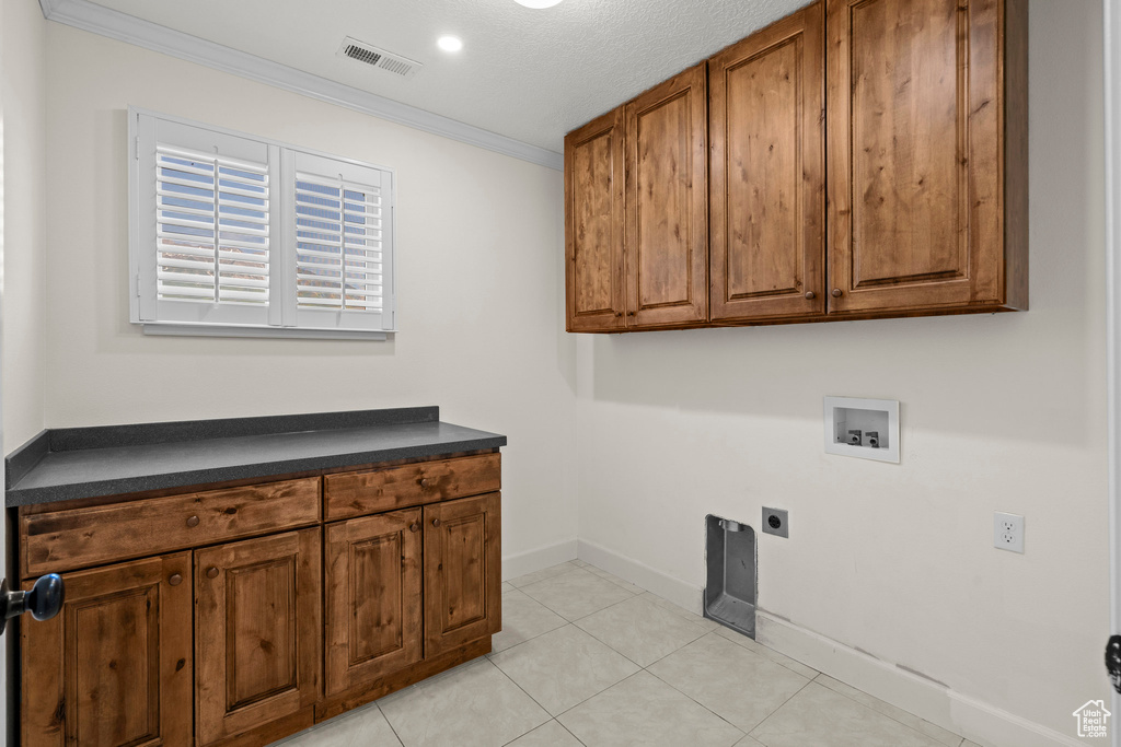 Laundry area featuring hookup for a washing machine, cabinet space, electric dryer hookup, ornamental molding, and baseboards