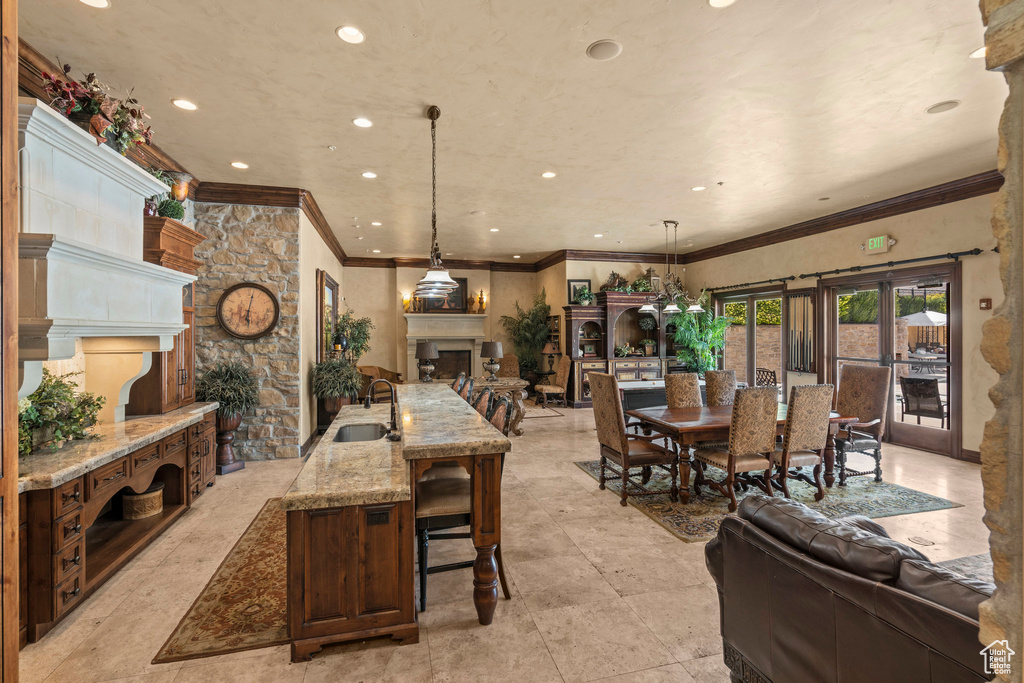 Dining room featuring a fireplace, ornamental molding, and recessed lighting