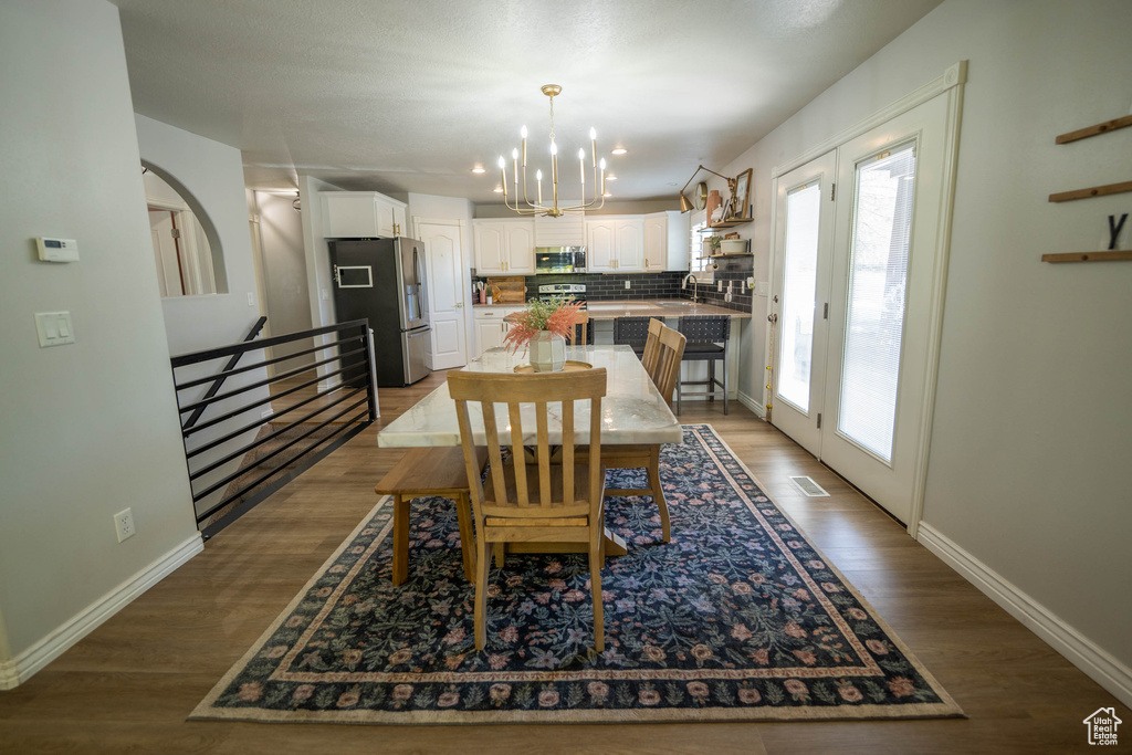 Dining space featuring a chandelier, wood finished floors, and baseboards