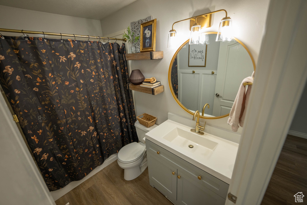 Full bath featuring wood finished floors, toilet, vanity, and a shower with curtain