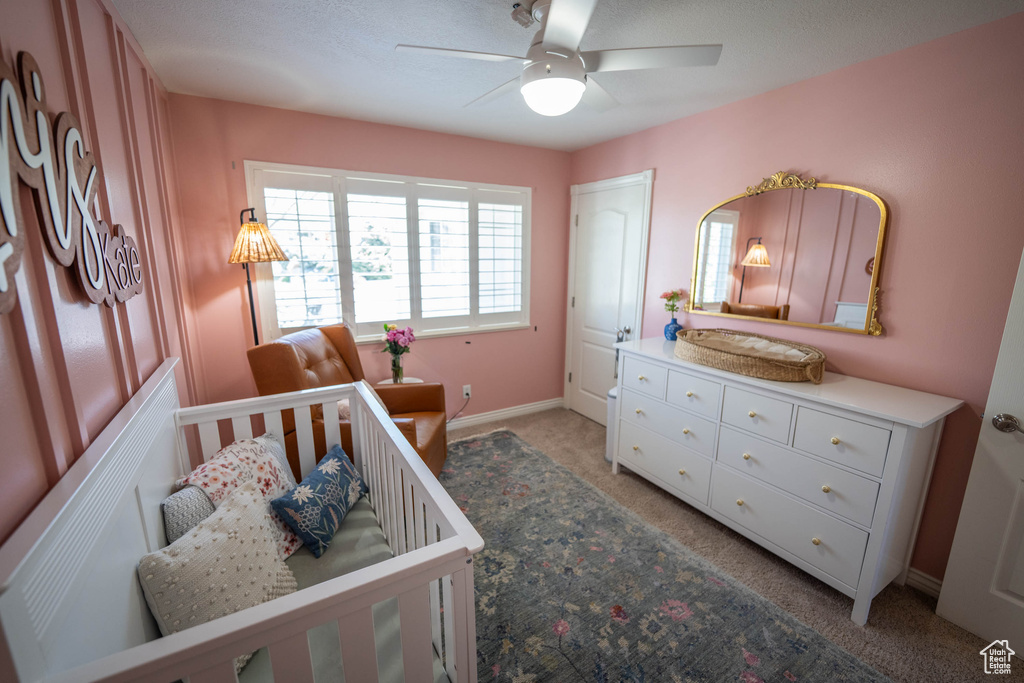 Bedroom featuring light colored carpet, baseboards, and ceiling fan