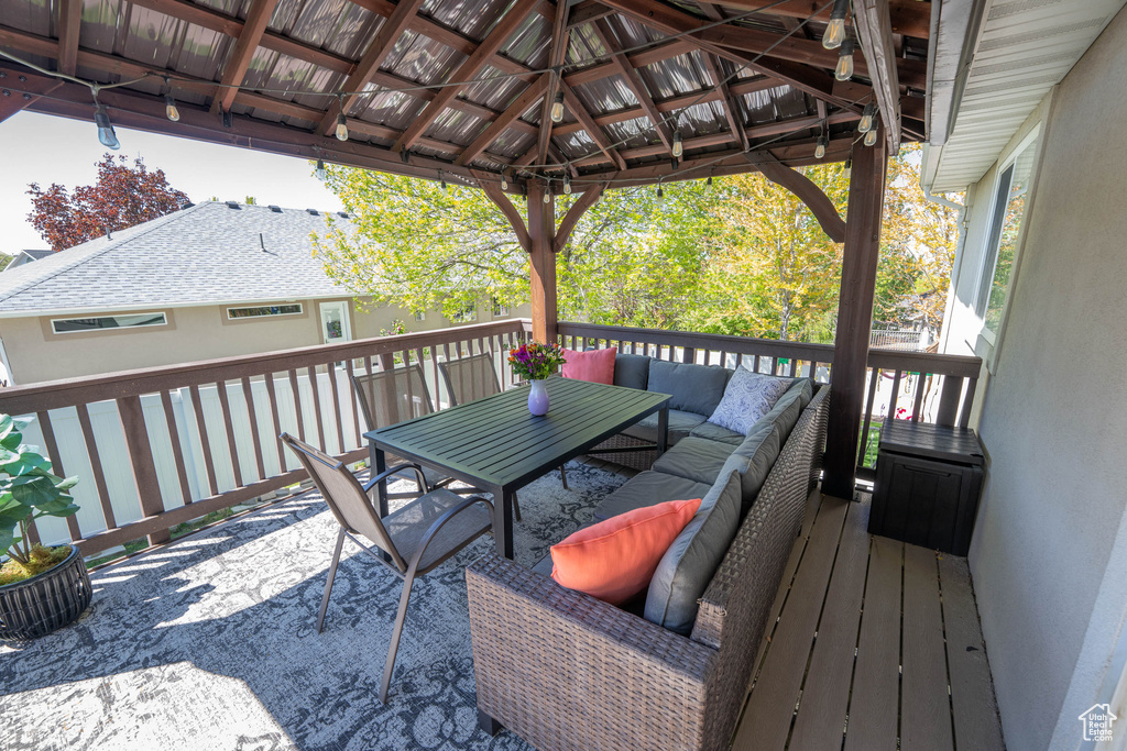 Wooden terrace featuring an outdoor living space, outdoor dining area, and a gazebo