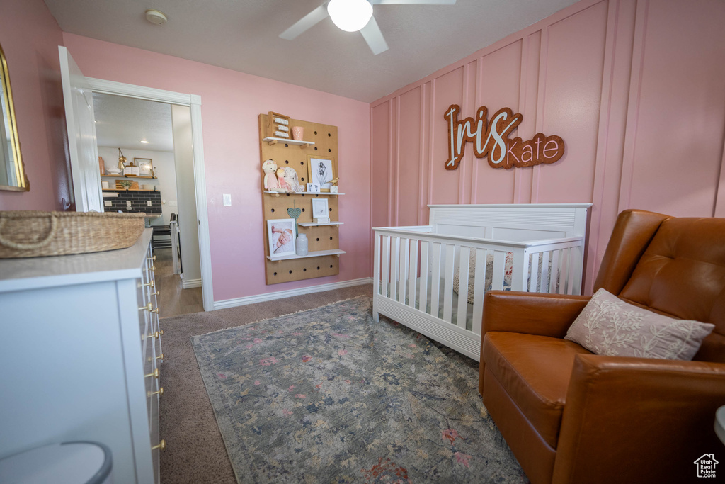 Bedroom with carpet, a crib, and ceiling fan