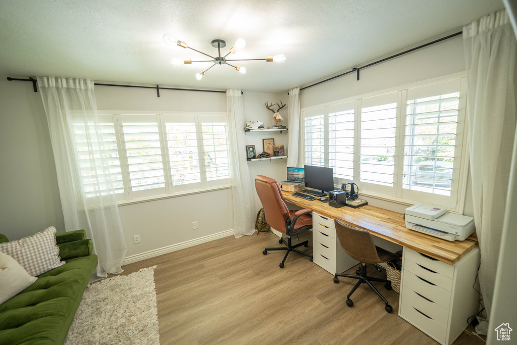 Home office featuring a chandelier, plenty of natural light, light wood-style flooring, and baseboards