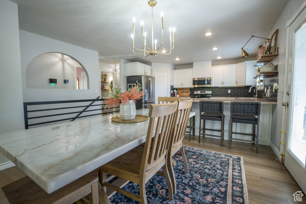 Dining room with a chandelier, light wood-style floors, plenty of natural light, and recessed lighting