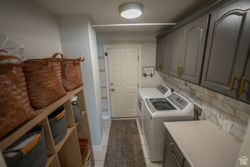 Laundry room featuring cabinet space, independent washer and dryer, and light tile patterned flooring