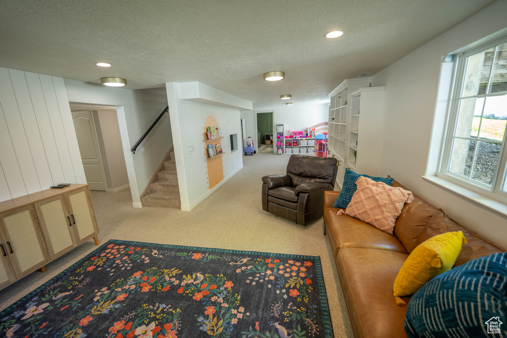 Living room with stairway, a textured ceiling, carpet floors, recessed lighting, and baseboards
