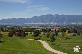 View of community featuring a mountain view, golf course view, and a lawn