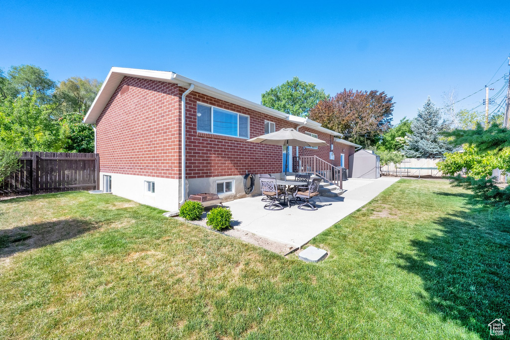Rear view of property with brick siding and a patio area