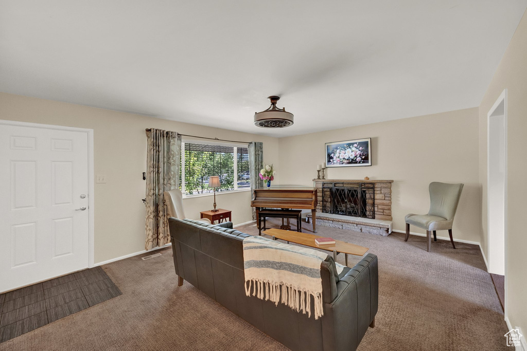 Living area with carpet flooring, a fireplace, and baseboards