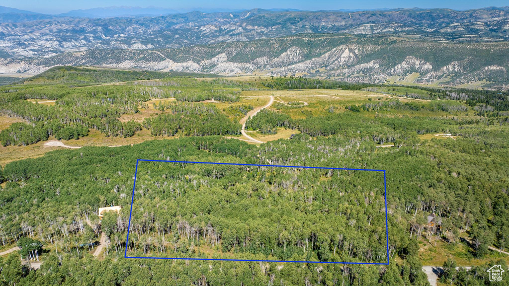 Aerial view of property's location featuring mountains, property boundaries highlighted, and a heavily wooded area