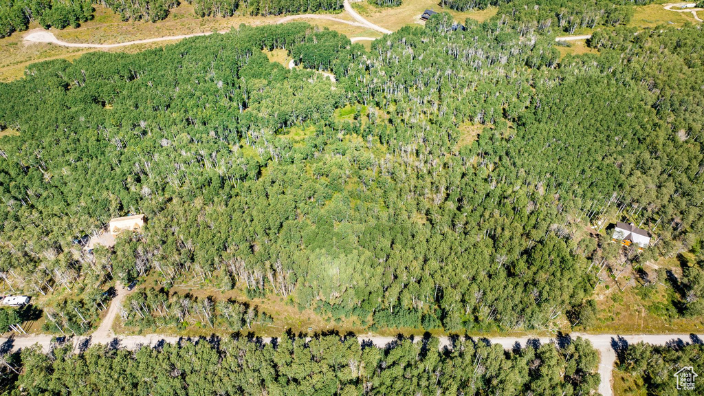 Aerial view of property and surrounding area featuring a heavily wooded area