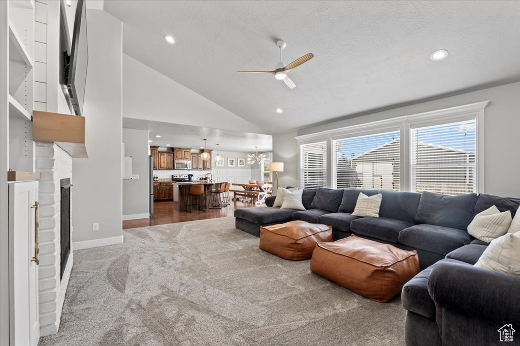 Living area with ceiling fan, carpet flooring, vaulted ceiling, recessed lighting, and baseboards