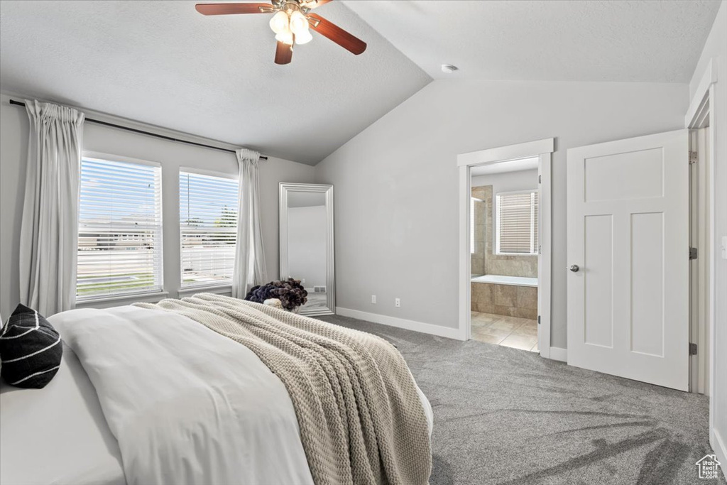 Bedroom with vaulted ceiling, carpet floors, baseboards, ensuite bathroom, and a ceiling fan