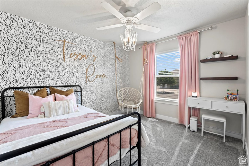 Carpeted bedroom featuring baseboards, ceiling fan, and a textured ceiling