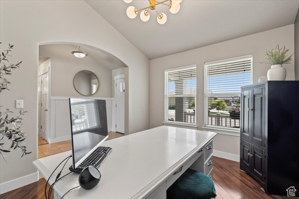 Home office with arched walkways, lofted ceiling, a chandelier, dark wood-type flooring, and baseboards