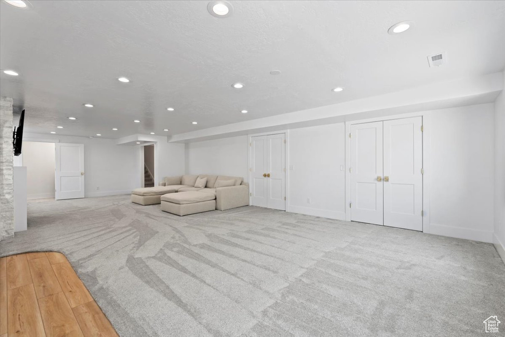 Living area with recessed lighting, baseboards, stairs, and carpet