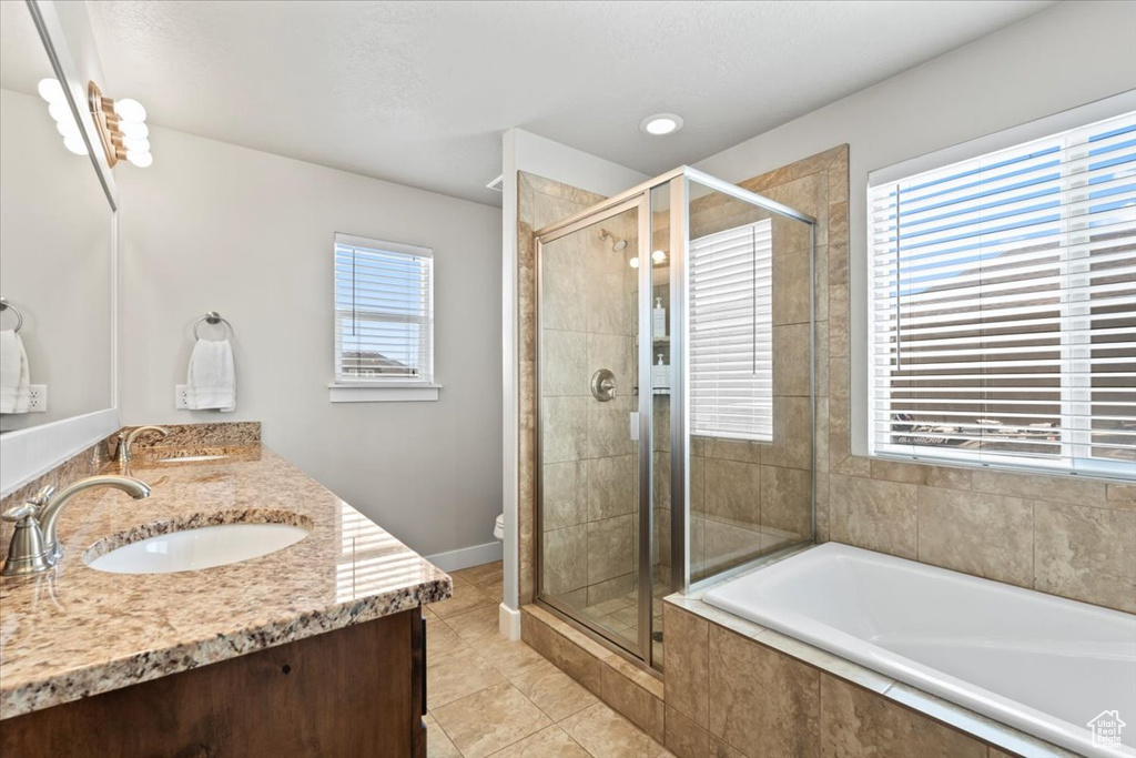 Bathroom with a garden tub, double vanity, a stall shower, and tile patterned flooring