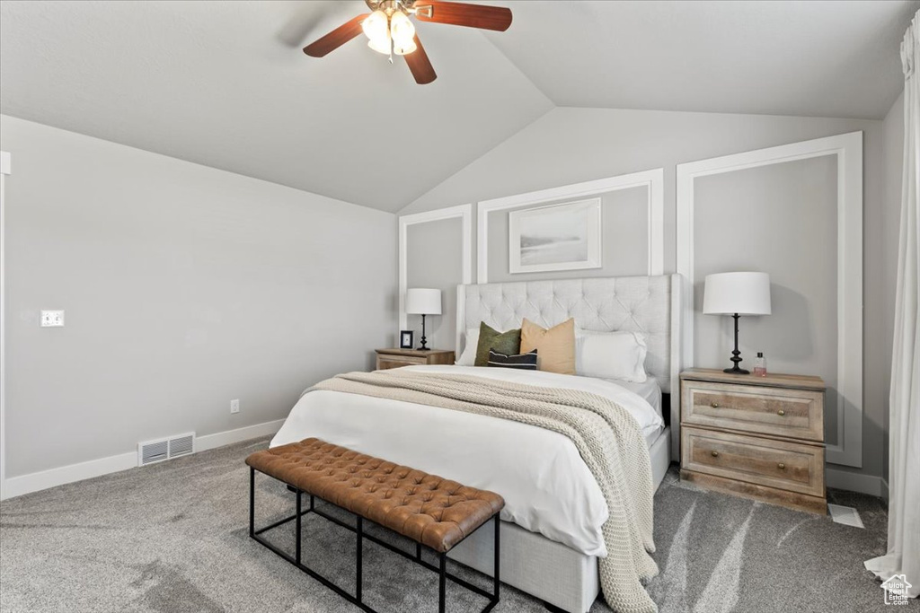 Carpeted bedroom with lofted ceiling, ceiling fan, and baseboards