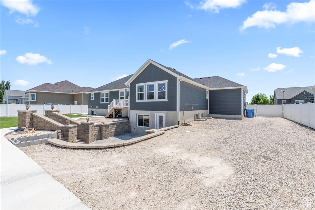 Rear view of house featuring a fenced backyard and stairs