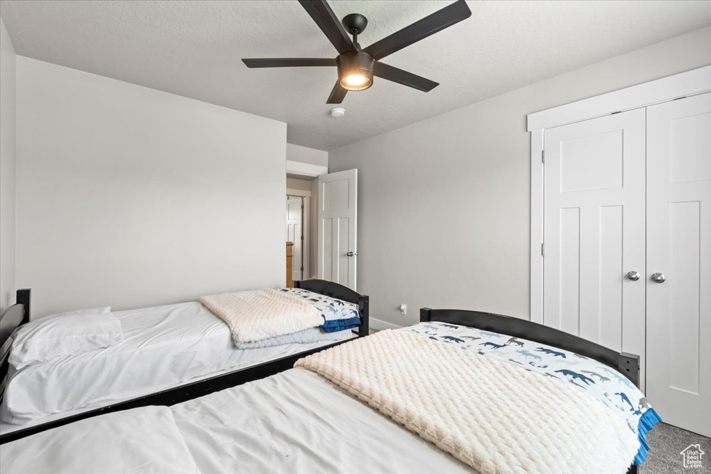 Carpeted bedroom with a closet and ceiling fan