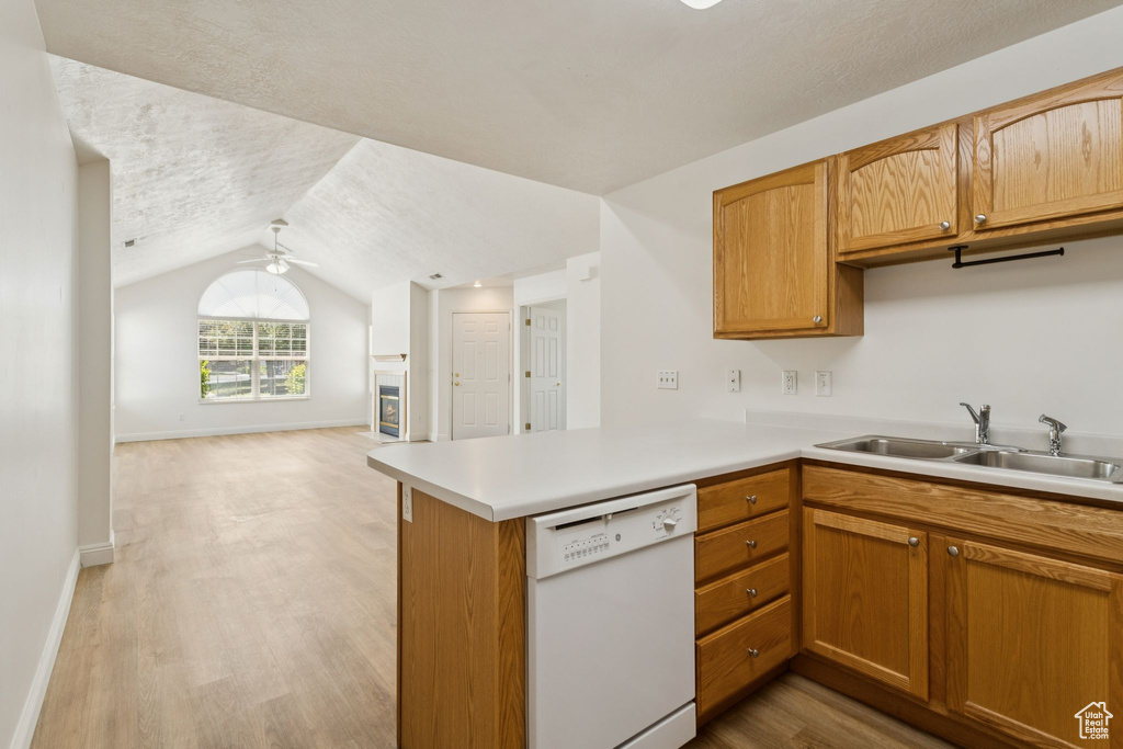 Kitchen featuring dishwasher, a sink, open floor plan, light countertops, and a ceiling fan